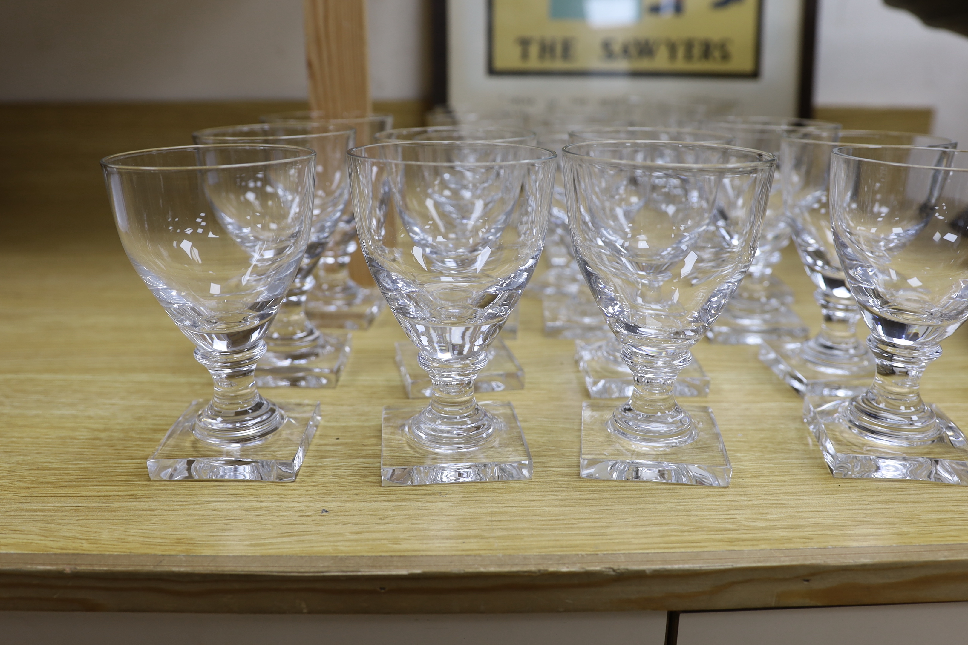 A set of twelve large square based glass rummers and a set of twelve similar smaller examples